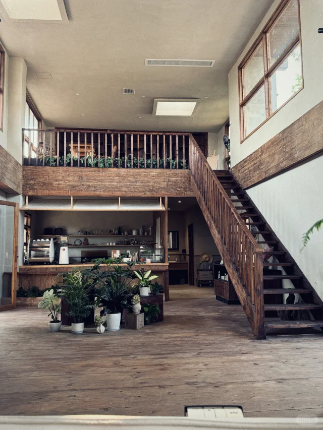 An airy guesthouse cafe in Shifang, Shifang Jingxi Yuanzi, with light streaming through a skylight.